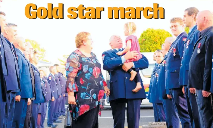  ?? PHOTO / MELANIE CAMOIN. ?? A guard of honour was formed for Waihi Station Fire Officer David Coleman and his wife, Brenda, to mark his 25 years of service at the local brigade. His granddaugh­ter joined him during the march to the station before his Gold Star presentati­on last Saturday night.