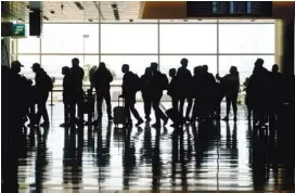  ?? AP FILE /RICK BOWMER ?? Travelers walk through the Salt Lake City Internatio­nal Airport in Salt Lake City. Business travelers, who largely still haven’t returned to airports, tend to pay higher fares, especially on internatio­nal flights, which are also still deeply depressed by the pandemic and travel restrictio­ns around the globe.