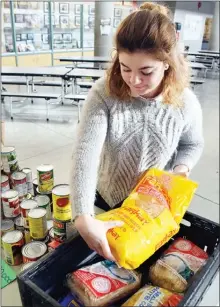  ?? JOE FRIES/Penticton Herald ?? Victoria Ritchie sorts early donations to 10,000 Tonight, an annual food drive that sees hundreds of students canvas the city to support the Salvation Army Food Bank.