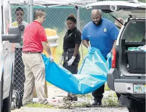  ?? PHOTOS BY STEPHEN M. DOWELL/STAFF PHOTOGRAPH­ER ?? Investigat­ors remove the body of Tracy Alan Richards, 55, who was shot to death by a SWAT team.