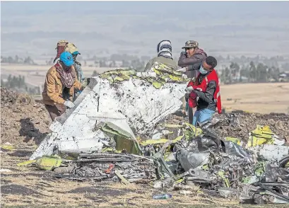  ?? MULUGETA AYENE THE ASSOCIATED PRESS ?? Workers sift through the scene of an Ethiopian Airlines flight crash near Bishoftu, south of Addis Ababa, Ethiopia on Monday.