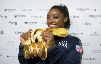  ?? MARIJAN MURAT — DPA VIA AP ?? Simone Biles of the United States shows her five gold medals she won at the Gymnastics World Championsh­ips in Stuttgart, Germany, Sunday.
