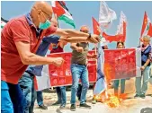  ?? AFP
— ?? Members of the Lebanese Communist Party burn a make-shift Israeli flag at a sit-in near the town of Naqoura on Tuesday, protesting against resumption of indirect talks on the demarcatio­n of the maritime border.