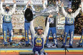  ?? RALPH FRESO / AP ?? Chase Elliott holds up the season championsh­ip trophy as he celebrates in Victory Lane after winning a NASCAR Cup Series race at Phoenix Raceway last year in Avondale, Ariz. Elliott will go for the repeat against Hendrick Motorsport­s teammate Kyle Larson and Joe Gibbs Racing teammates Denny Hamlin and Martin Truex Jr.