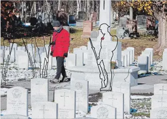  ?? FRED CHARTRAND THE CANADIAN PRESS ?? A man walks by metal cutouts representi­ng Canadian soldiers during Remembranc­e Day ceremonies at the National Military Cemetery in Ottawa.