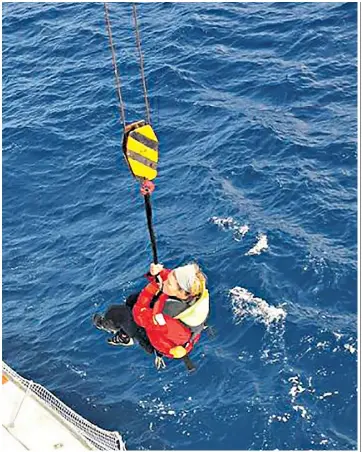  ??  ?? Susie Goodall is winched aboard the cargo ship MV Tian Fu off Cape Horn in the Southern Ocean after her boat, left, capsized