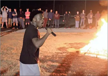  ?? Photos by Spencer Lahr, Rome News-Tribune ?? ABOVE: Rome Wolves running back Jamar Roberts fires up the crowd gathered for a bonfire at Rome High School on Thursday night as the football team prepares for the state semifinal game with Buford tonight at Barron Stadium. Tickets will cost $15 at the...