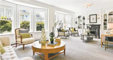  ?? Photos by Open Homes Photograph­y ?? The living room has divided light windows, hardwood flooring and a dramatic fireplace.