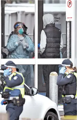  ??  ?? Medical staff perform a COVID-19 test on a resident of one of nine public housing estates locked down due a spike in infection numbers in Melbourne yesterday. Australia will effectivel­y seal off the state of Victoria from the rest of the country. — AFP