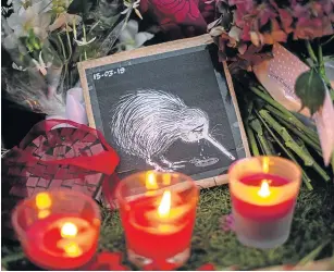  ?? Picture: GETTY IMAGES/ CARL COURT ?? MOURNING: Candles burn next to a picture of a weeping kiwi that has been laid among other tributes by the wall of the Botanic Gardens in Christchur­ch, New Zealand on Sunday.