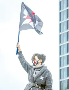  ?? — AFP photo ?? Suchanow waves a flag during a pro-choice protest marking the 102nd anniversar­y of the women’s voting rights in Poland, in Warsaw.