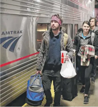  ?? SCOTT OLSON/GETTY IMAGES ?? Passengers board an Amtrak train at Union Station before Thanksgivi­ng in 2018.