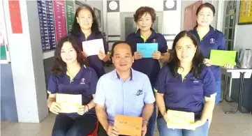  ??  ?? (Seated from left) Yu, Chin, Ling and other committee members show the admission tickets to the mooncake-making event.