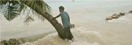  ?? Photo: Jeremy Sutton-Hibbert ?? A king tide crashes through the sea wall, flooding Pita Meanke’s family home on the low-lying South Pacific island of Kiribati.