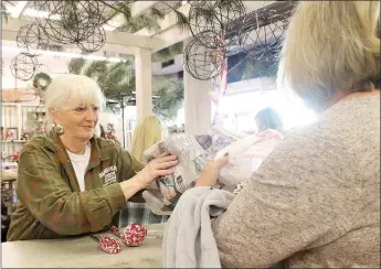  ?? LYNN KUTTER ENTERPRISE-LEADER ?? Martha Ritchie, owner of Daisies and Olives, waits on a customer during the store’s 20th anniversar­y and open house celebratio­n.