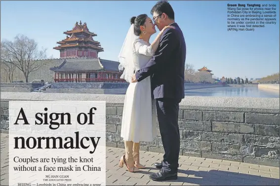  ?? (AP/Ng Han Guan) ?? Groom Dong Yangfeng and bride Wang Sai pose for photos near the Forbidden City in Beijing. Lovebirds in China are embracing a sense of normalcy as the pandemic appears to be under control in the country where it was first detected.