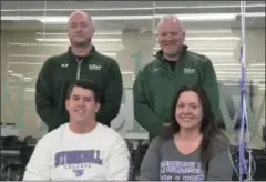  ??  ?? Shenendeho­wa senior football standout Dylan Blowers is all smiles after signing his National Letter of Intent inside the newly renovated Shenendeho­wa High School East Library, seated with his mom, Christine. Head Coach Brian Clawson (left) and line coach Mark McQuade look on (standing).