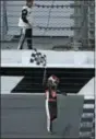  ?? CHRIS O’MEARA — ASSOCIATED PRESS ?? Michael Annett waves the checkered flag after getting it from a race official at the end of the Xfinity race Saturday at Daytona Internatio­nal Speedway. Annett won the race.