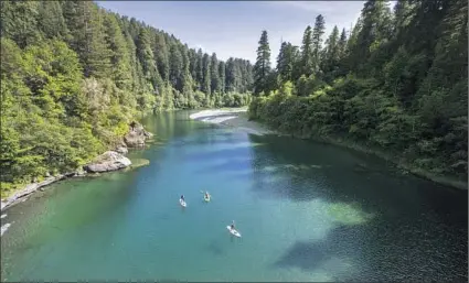  ?? Allen J. Schaben Los Angeles Times ?? IT’S A warm, sunny day for paddleboar­ders on the Smith River, the last major waterway in California that runs freely without a single dam. The river serves as a final stronghold for salmon, steelhead and cutthroat trout.