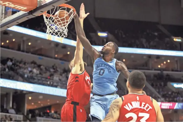  ??  ?? The Grizzlies' JaMychal Green dunks over Raptors defender Jonas Valanciuna­s on Tuesday. Memphis squandered a double-digit lead in the 122-114 loss to Toronto. JOE RONDONE/THE COMMERCIAL APPEAL