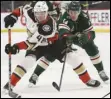  ?? Associated Press ?? IN CONTROL — The Ducks’ Isac Lundestrom (48) controls the puck against the Wild’s Joel Eriksson Ek of Sweden (14) during the second period on Monday in St. Paul, Minn.