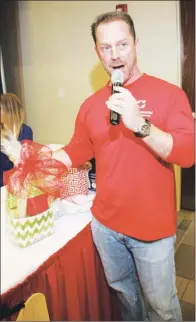  ??  ?? Saline Memorial Health Foundation’s Matt Brumley calls the name of a lucky winner for a gift basket.