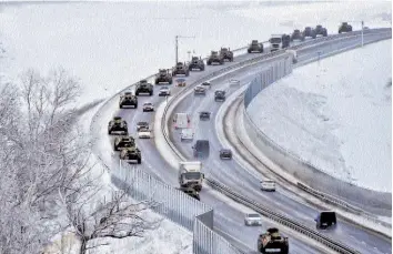  ?? — AP ?? A convoy of Russian armoured vehicles moves along a highway in Crimea. They are participat­ing in military drills that are alleged to be aimed at unsettling Ukraine.