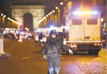  ?? Thibault Camus / Associated Press ?? A police officer stands guard after the fatal shooting of a police officer on Paris’ Champs-Élysées.