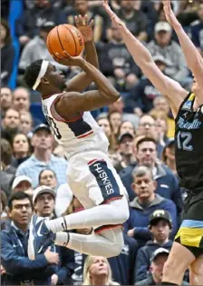  ?? Jessica Hill/Associated Press ?? Connecticu­t’s Hassan Diarra, left, gets a shot off against Marquette’s Ben Gold in a matchup featuring top-five teams in Hartford, Conn.