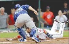  ?? The Associated Press ?? Edwin Encarnacio­n of the Cleveland Indians is tagged out at home plate by Toronto Blue Jays catcher Russell Martin during fourth-inning AL action on Friday in Cleveland.The Blue Jays lost 13-3.