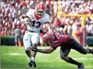  ?? / AP-Sean Rayford ?? Georgia running back Elijah Holyfield (13) runs with the ball against South Carolina defensive back Keisean Nixon (9) during the first half of an NCAA game in Columbia, S.C., on Saturday.