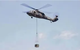  ?? Ned Gerard/Hearst Connecticu­t Media file photo ?? A Sikorsky UH-60A Black Hawk helicopter hovers with a payload at Sikorsky Memorial Airport in Stratford in July.