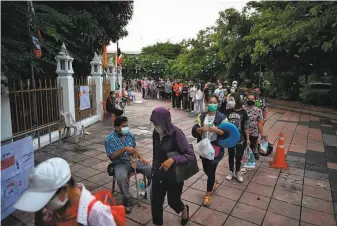  ?? Lillian Suwanrumph­a / AFP via Getty Images ?? People line up for free COVID19 swab testing in Bangkok. The number of new infections and deaths have soared to record levels in Thailand, spurred by the spread of the delta variant.