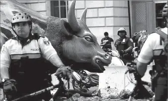  ?? -AP ?? Climate change activists are surrounded by police as they protest at the Wall Street Bull in Lower Manhattan during Extinction Rebellion protests.