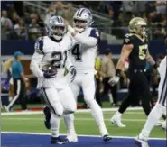  ?? MICHAEL AINSWORTH — THE ASSOCIATED PRESS ?? Dallas Cowboys running back Ezekiel Elliott (21) celebrates his touchdown against the New Orleans Saints with quarterbac­k Dak Prescott (4) in the first half of an NFL football game, in Arlington, Texas, Thursday.