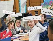 ??  ?? Students display some of their cursive writing work and exercises Wednesday at P.S. 166 in the Queens borough of New York. Cursive writing is looping back into style in schools across the country after a generation of students who know only...