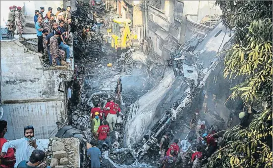  ?? FAREED KHAN / AP ?? Restos del avión, entre ellos uno de los motores, en una estrecha calle del barrio de Model Town, en Karachi (Pakistán)