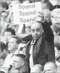  ?? GLYN KIRK / AGENCE FRANCE-PRESSE ?? An Arsenal fan holds up a poster at Emirates Stadium in North London on Saturday, urging Arsenal manager Arsene Wenger to buy some new players.