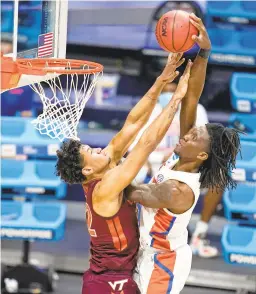  ?? MICHAEL CONROY/AP ?? Florida forward Anthony Duruji tries to dunk the ball over Virginia Tech forward Keve Aluma during a first-round NCAA Tournament game last Friday.