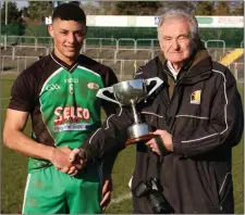  ??  ?? Kilkenny’s Pat Henderson presents Scoil Chonglais captain Jordan Deans with the South Leinster ‘D’ cup.