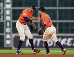  ?? RONALD MARTINEZ, GETTY IMAGES ?? Carlos Correa, left, and Jose Altuve celebrate Houston’s 2-0 series lead.