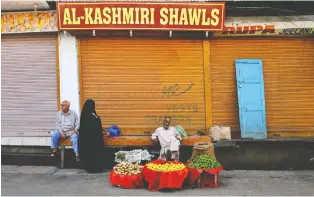  ?? PHOTOS: MUKHTAR KHAN/THE ASSOCIATED PRESS ?? ABOVE: Vegetable seller Mohammad Yousuf says he is seeing people buying vegetables “like never before.” AVOVE RIGHT: A Kashmiri farmer washes vegetables on the banks of a river on the outskirts of Srinagar.