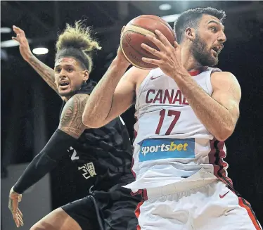  ?? SAEED KHAN GETTY IMAGES ?? Canadian forward Owen Klassen, right, pulls down a rebound while shielding off New Zealand’s Issac Fotu during a pre-FIBA World Cup friendly in Sydney, Australia, on Tuesday. Canada’s roster is now down to one active NBA player.