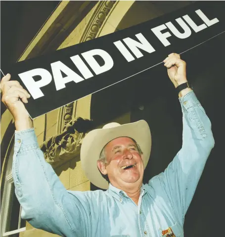  ?? COLLEEN DE NEVE FILES ?? Former premier Ralph Klein held up a paid in full sign after announcing that the province's debt of $3.7-billion had been paid off in full ahead of schedule. Klein made the announceme­nt following his annual Stampede breakfast at the Mcdougall Centre in Calgary in 2004.