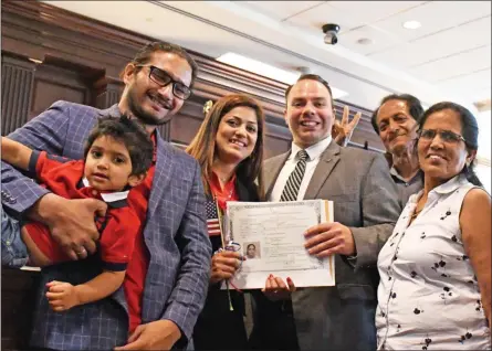  ?? PHOTO COURTESY OF CHESTER COUNTY ?? Chester County Prothonota­ry Matt Holliday, center, and commission­ers’ Chairwoman Michelle Kichline, at right, welcome one of the new citizens at naturaliza­tion ceremonies.