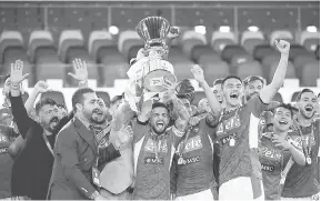  ?? — Gambar AFP ?? KOLEKSI TROFI: Gambar fail ini menunjukka­n pasukan Napoli menjulang trofi kejuaraan selepas menumpaska­n Juventus pada final Piala Itali bulan Jun lalu.