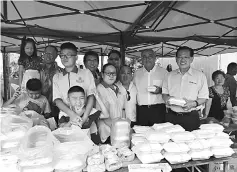  ??  ?? (From right) Lee,Yii, Leong (rear, left) and the event organising committee pose for a photo with stall operators at the charity sale.