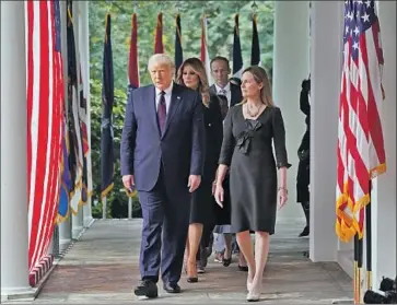  ?? Alex Brandon Associated Press ?? PRESIDENT TRUMP walks with Judge Amy Coney Barrett to a news conference at the White House, where he described his Supreme Court nominee as “one of our nation’s most brilliant and gifted legal minds.”