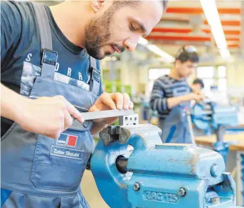  ?? FOTO: ROBERT HACK ?? Zahler Shalabi bearbeitet an einem Schraubsto­ck ein Werkstück: Der 28-Jährige stammt aus Syrien und studierte Wirtschaft­swissensch­aften, bevor er aus seiner Heimat nach Europa floh.