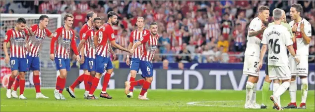  ??  ?? GOLEADA PREDERBI. Los jugadores del Atlético felicitan a Koke por su gol al Huesca, después de que el VAR confirmara que Correa ni estaba en fuera de juego ni tocó balón.